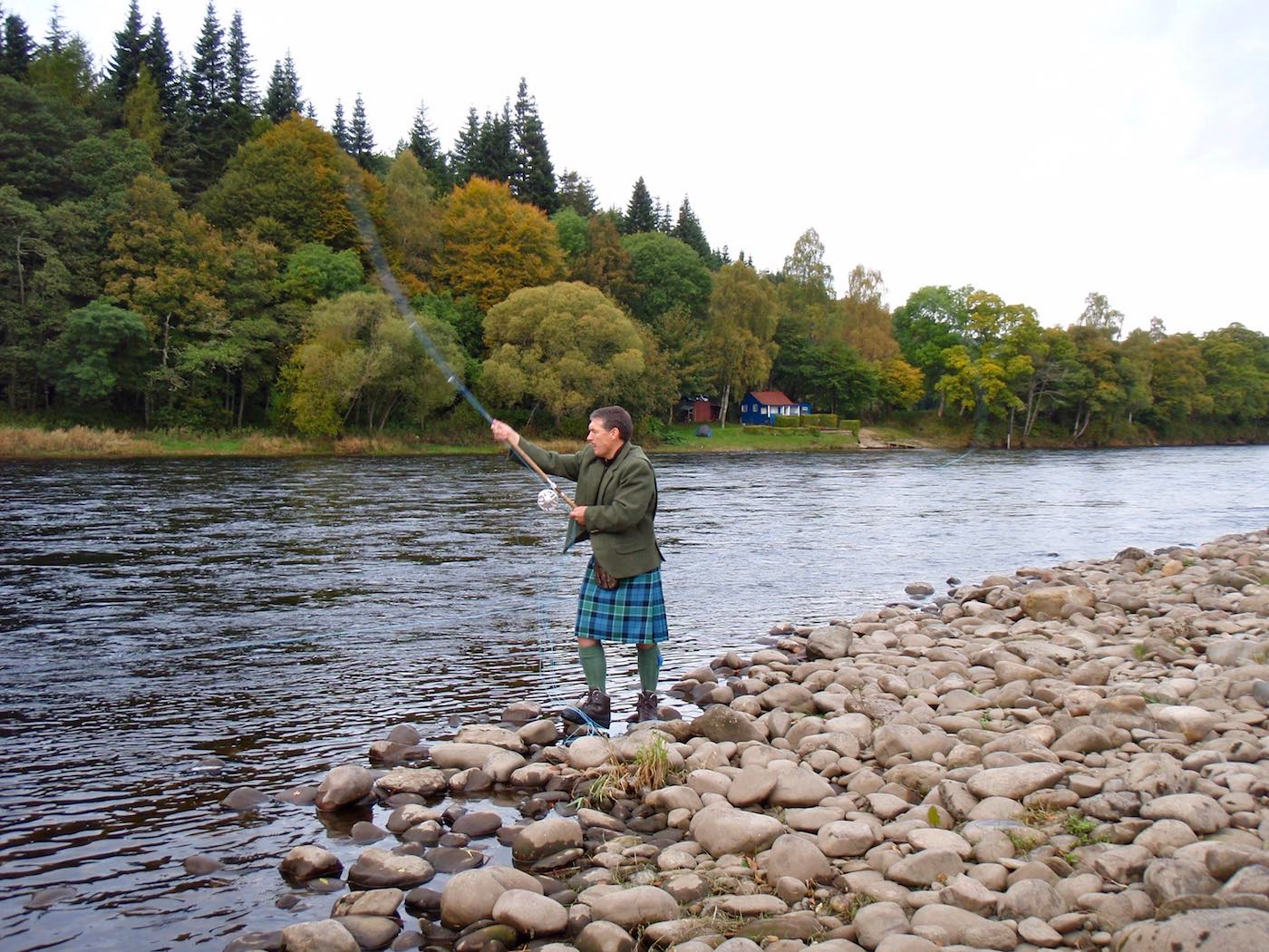 Here's professional salmon fishing guide Jock Monteith demonstrating the single Spey right hand up cast with his Graham of Menteith tartan kilt and lovat green Tweed jacket. The blue fishing hut across the river is the Newtyle Beat fishing hut near Dunkeld where Jock served as Head Ghillie for a decade. This shot was taken at the neck of the Newtyle Beat's Boil Pool.