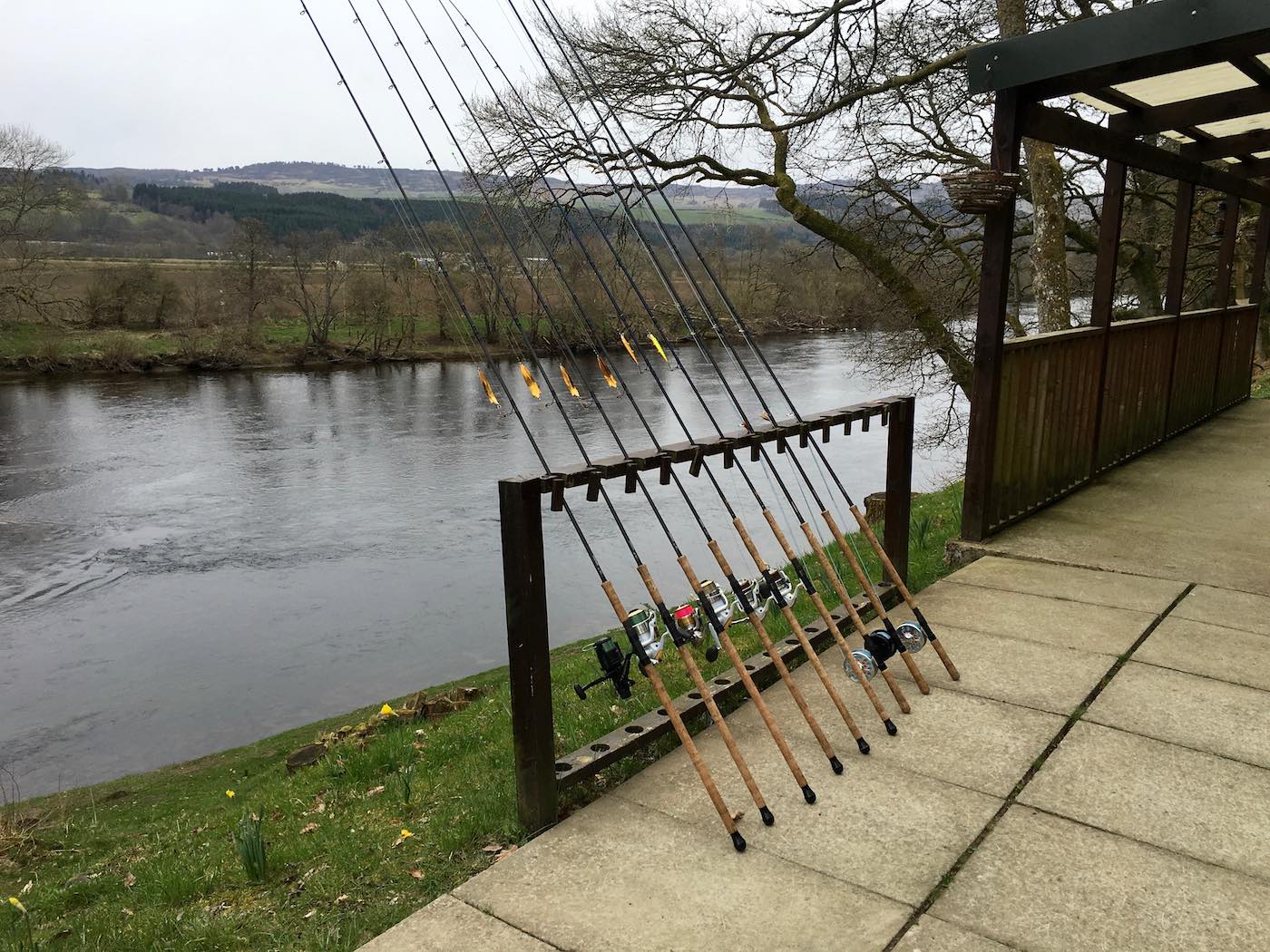 Here's a perfect line up of River Tay spin fishing rods on the rod rack outside of the Upper Kinnaird salmon fishing hut. This shot was taken at 8am in the morning by the salmon guide before the salmon fishing trip guests turned up for their day on the river. You can see the ripple in the river behind the rods which is a serious salmon lie.