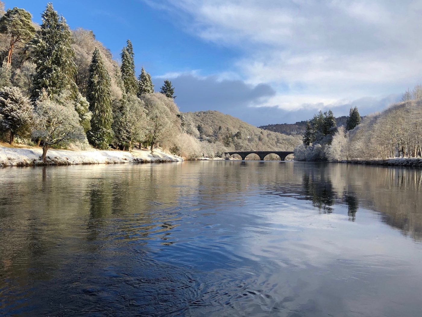 Here's a fine Winter shot of a downstream view of the River Tay taken by the River Tay boatman at Dunkeld. Note the historic 200 year old Telford Bridge in the distance which is one of the Tay's most famous sandstone bridges. This shot was taken during late January after some local snow fall.