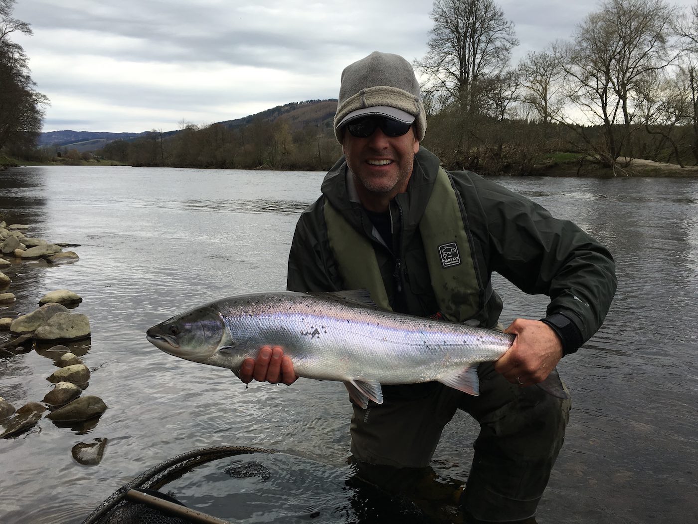 This happy American salmon fishing guest landed this perfect salmon on a cold & dull early Spring day with the assistance of myself as his salmon guide. The leader material we were using was good old 'time tested' Maxima Chameleon which has always been my leader material of choice. This salmon fishing guest has a warm hat on and a life jacket too for wading safety reasons.