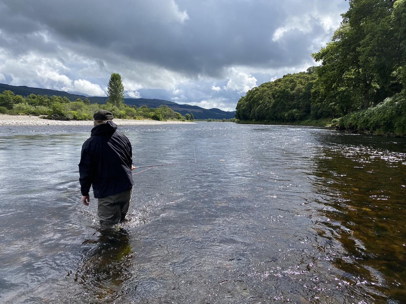 This photo of a guided salmon fishing guest was taken on the River Tay near Pitlochry which is a very good fishing area. He has chest waders, life jacket and a double handed salmon fly rod which are essential salmon fishing kit that his salmon fishing guide supplied.