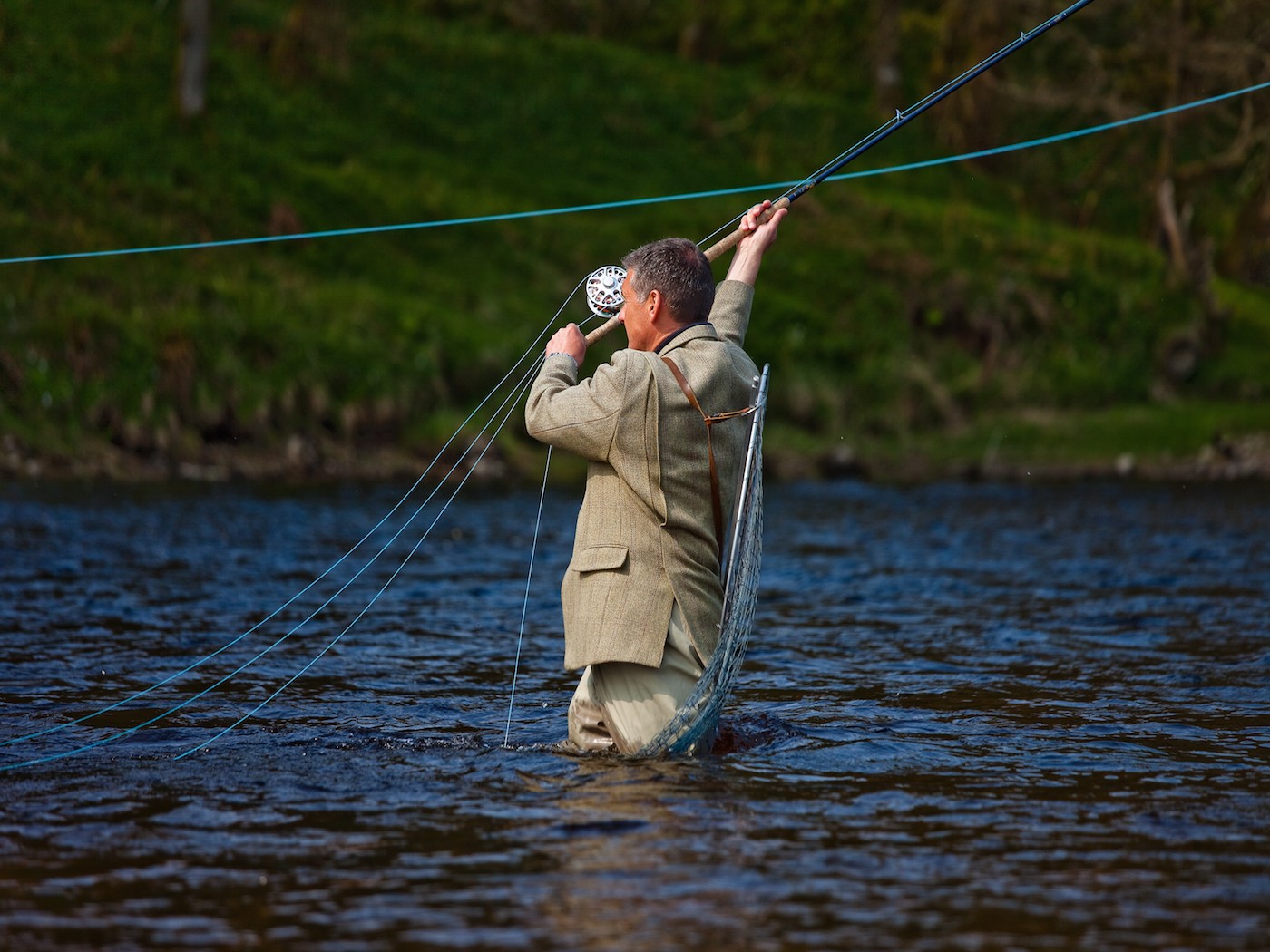 This perfectly timed photograph was taken by professional photographer Louise Bellin on the Kinnaird Beat of the River Tay at the famous Junction Pool which is directly where the River Tummel enters the Tay. Jock, dressed in traditional Tweeds and waders holds his fishing rod, demonstrating the perfect Spey cast required in this salmon fishing hot spot for maximum water coverage of the lovely Tay salmon pool.