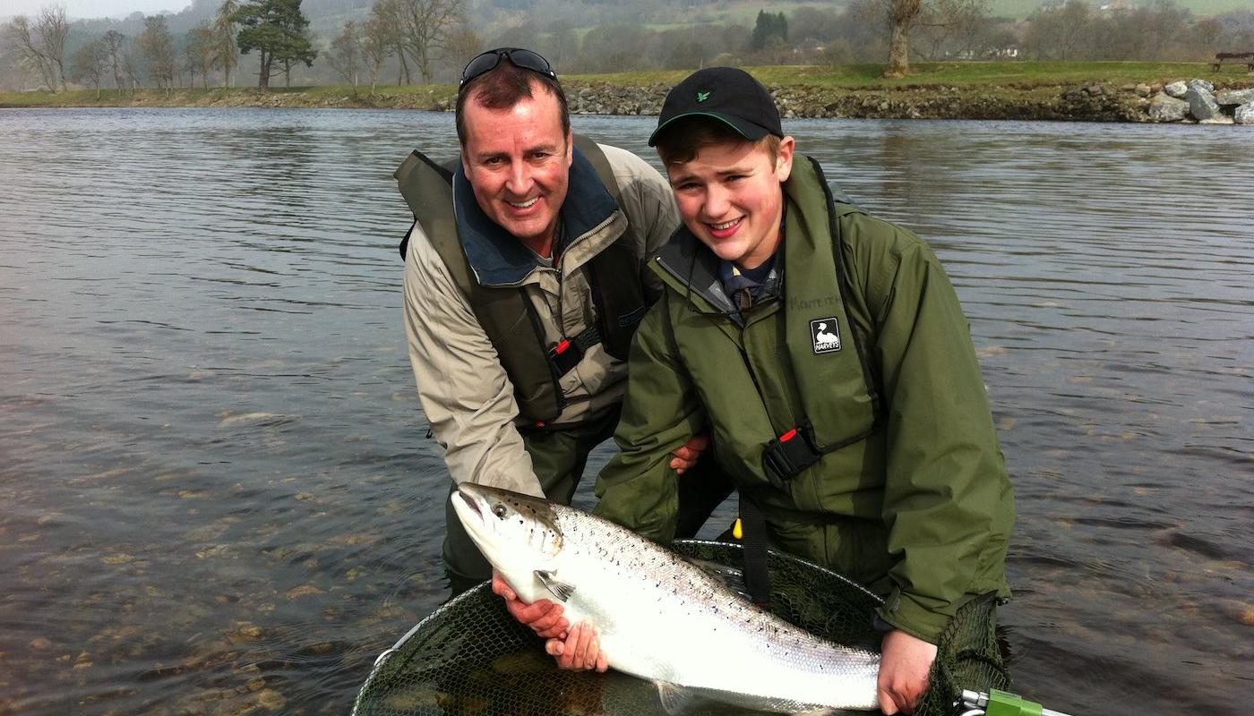 This young man landed 2 almost identical heavyweight Spring salmon during late March on the River Tay. He achieved this after a 30 minute crash course on how to use a double handed salmon rod on the Ash Tree Pool of the River Tay near Pitlochry. This was the 2nd Spring salmon he caught so I took this shot of him and his father while accompanying them as their personal salmon fishing guide. What a memorable morning that was!